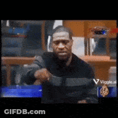 A Blurry Picture Of A Man Holding A Gun In Front Of A Sign That Says Viggle GIF