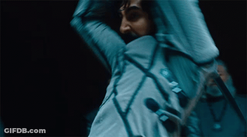A Blurry Picture Of A Man Holding A Microphone With A Sticker On His Jacket That Says ' A ' On It GIF