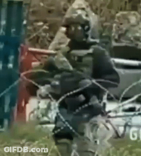 A Blurry Picture Of A Man Holding A Rifle With The Word Gi On The Bottom GIF