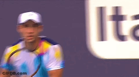 A Blurry Picture Of A Man Holding A Tennis Racquet In Front Of A Sign That Says Lite GIF