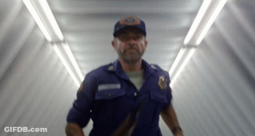 A Blurry Picture Of A Man In A Blue Uniform With A Badge That Says ' Emergency ' On It GIF