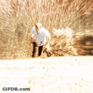 A Blurry Picture Of A Man In A Cowboy Hat Standing In The Sand GIF