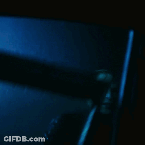 A Blurry Picture Of A Man In A Dark Room With A Blue Background GIF
