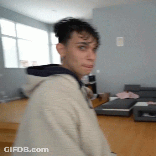 A Blurry Picture Of A Man In A Living Room With A Couch . GIF
