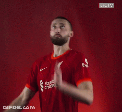 A Blurry Picture Of A Man In A Red Shirt Holding A Soccer Ball In His Hand . GIF
