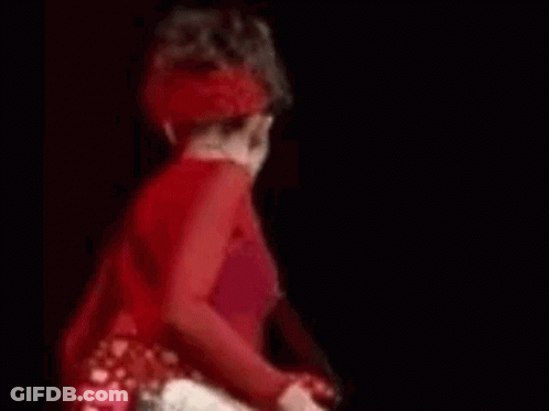A Blurry Picture Of A Man In A Red Shirt Making A Funny Face . GIF