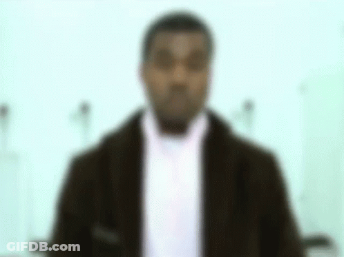 A Blurry Picture Of A Man In A Suit And Scarf . GIF