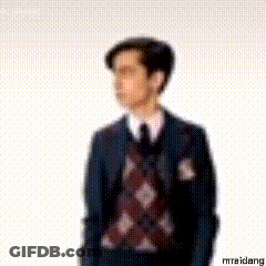 A Blurry Picture Of A Man In A Suit And Tie Standing In Front Of A White Background . GIF