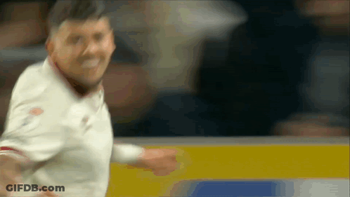 A Blurry Picture Of A Man In A White Shirt Standing In Front Of A Wall GIF