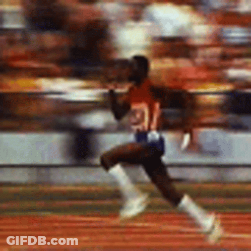 A Blurry Picture Of A Man Running On A Track With A Crowd In The Background . GIF