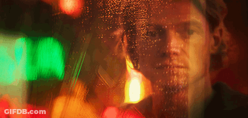A Blurry Picture Of A Man 'S Face Behind A Window With A Green Light Behind Him GIF