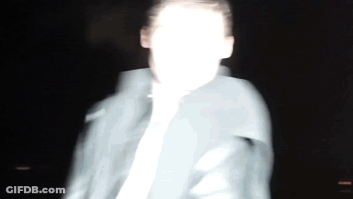 A Blurry Picture Of A Man 'S Face In The Dark GIF