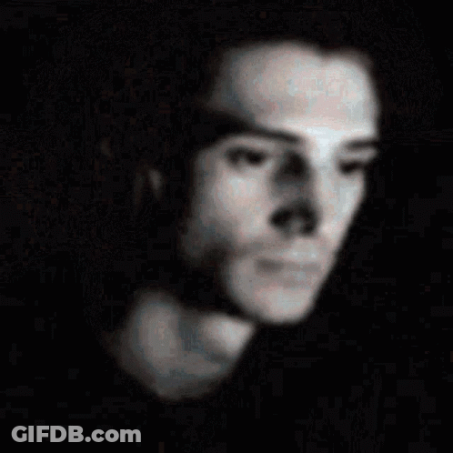A Blurry Picture Of A Man 'S Face With A Black Background GIF