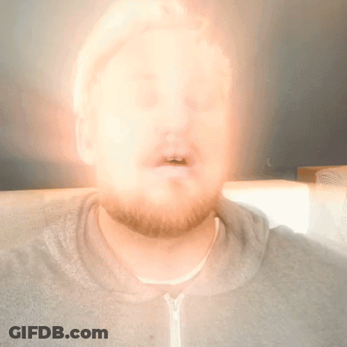 A Blurry Picture Of A Man 'S Face With A Light Shining On It GIF