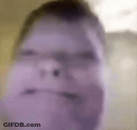 A Blurry Picture Of A Man 'S Face With A Purple Background . GIF