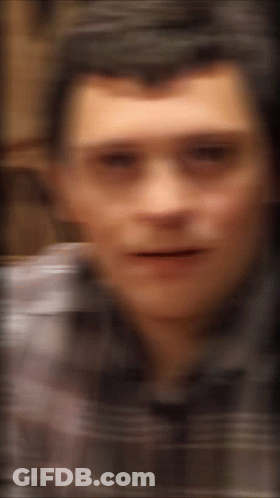 A Blurry Picture Of A Man 'S Face With A Striped Shirt On GIF