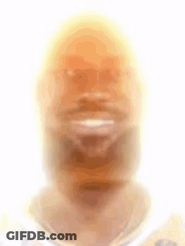 A Blurry Picture Of A Man 'S Face With A Yellow Hat On GIF