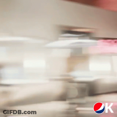 A Blurry Picture Of A Man Sitting At A Table With A Pepsi Logo GIF