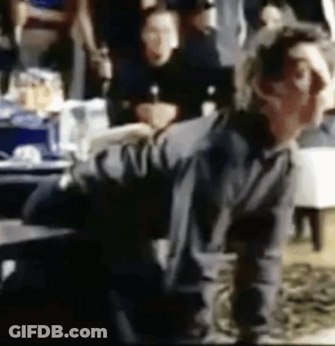 A Blurry Picture Of A Man Sitting In A Chair GIF