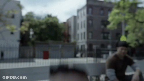 A Blurry Picture Of A Man Sitting In Front Of A Yellow Sign GIF