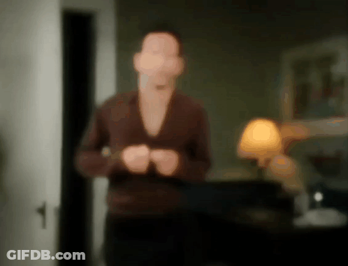 A Blurry Picture Of A Man Standing In A Living Room GIF