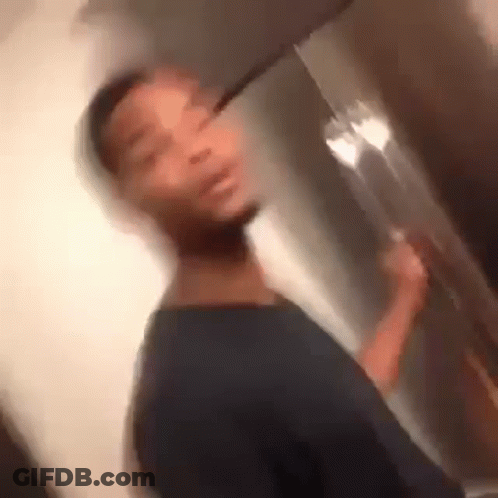 A Blurry Picture Of A Man Standing In Front Of A Refrigerator Holding A Fork . GIF
