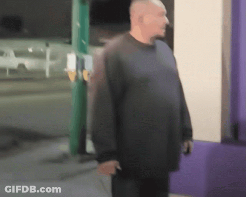 A Blurry Picture Of A Man Standing In Front Of A Store GIF