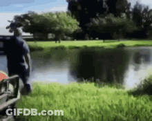 A Blurry Picture Of A Man Standing Next To A Body Of Water GIF