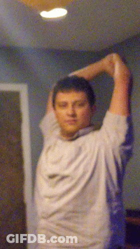A Blurry Picture Of A Man Stretching His Arms In A Room GIF