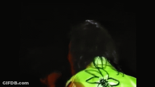 A Blurry Picture Of A Man Talking To Another Man In A Yellow Jacket . GIF