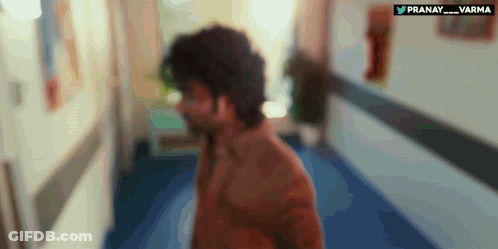 A Blurry Picture Of A Man Walking Down A Hallway With The Words Pranay Varma Written On The Bottom GIF