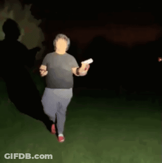 A Blurry Picture Of A Man Walking In The Dark Holding A Frisbee . GIF
