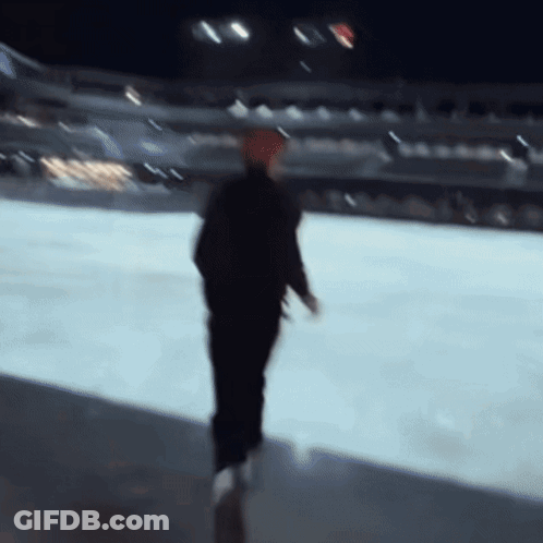 A Blurry Picture Of A Man Walking On A Ice Rink GIF