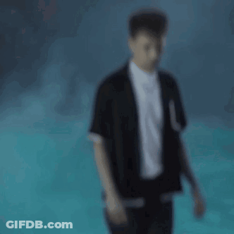 A Blurry Picture Of A Man Wearing A Black Jacket And White Shirt . GIF