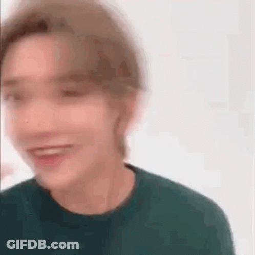 A Blurry Picture Of A Man Wearing A Green Sweater . GIF