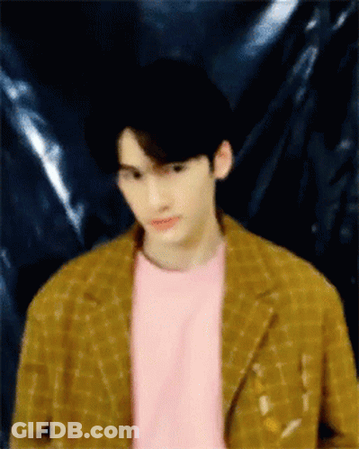 A Blurry Picture Of A Man Wearing A Pink Shirt And A Yellow Jacket GIF