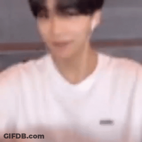 A Blurry Picture Of A Man Wearing A White T-Shirt . GIF