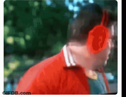 A Blurry Picture Of A Man Wearing Headphones And A Red Jacket GIF