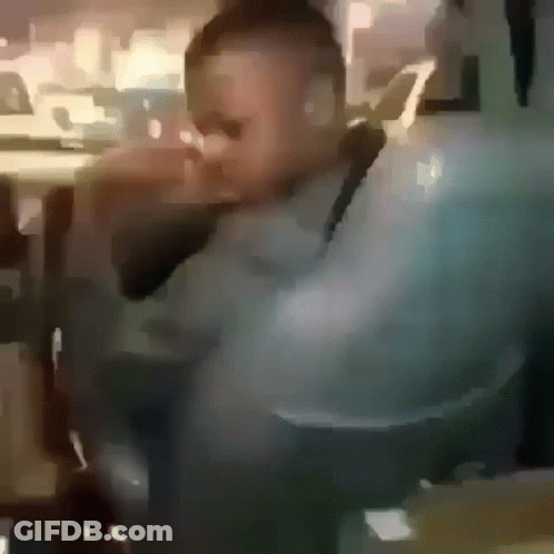A Blurry Picture Of A Man Wearing Sunglasses Sitting In A Chair . GIF