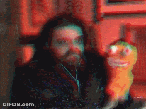 A Blurry Picture Of A Man With Ear Buds And A Stuffed Animal GIF