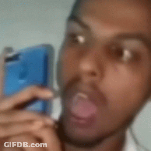 A Blurry Picture Of A Man With His Mouth Open And His Tongue Out . GIF