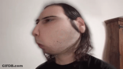 A Blurry Picture Of A Man With Long Hair And A Beard GIF