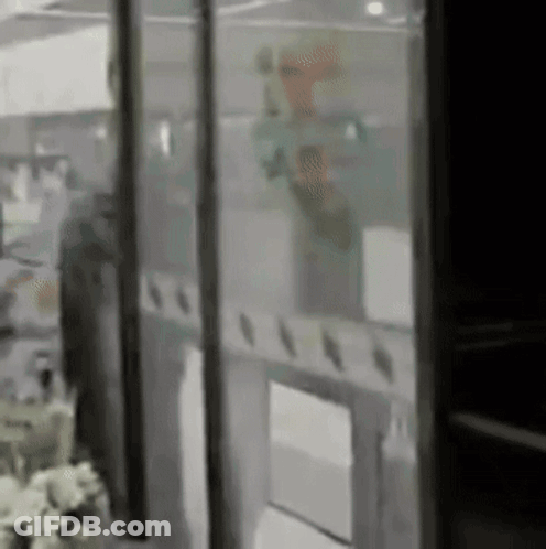 A Blurry Picture Of A Person Behind A Glass Door In A Room . GIF