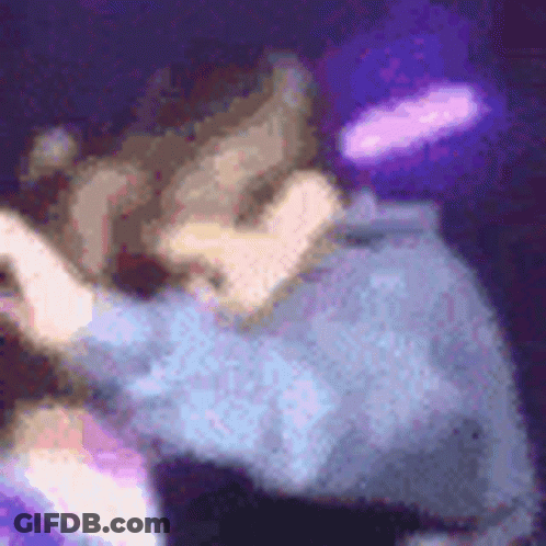 A Blurry Picture Of A Person Dancing On A Stage With Purple Lights In The Background . GIF