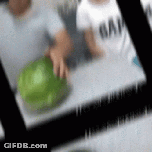 A Blurry Picture Of A Person Holding A Green Ball GIF