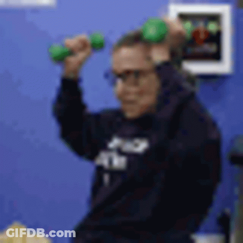 A Blurry Picture Of A Person Holding A Green Dumbbell In Their Hands . GIF