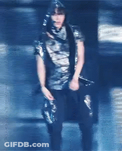 A Blurry Picture Of A Person Holding A Microphone In A Dark Room GIF