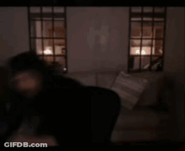 A Blurry Picture Of A Person Holding A Remote Control In A Dark Room . GIF
