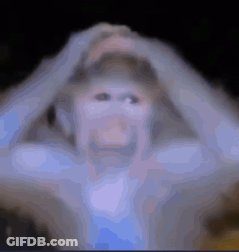 A Blurry Picture Of A Person Holding Their Head With Their Hands GIF
