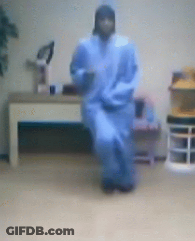 A Blurry Picture Of A Person In A Blue Robe Dancing In A Room GIF
